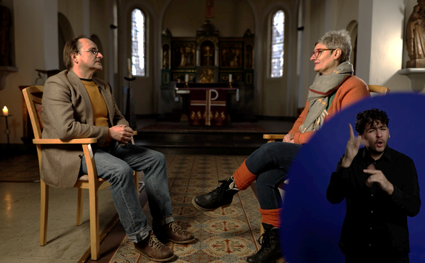 Standbildaufnahme aus dem Film: Interviewsituation, Betroffene erzählen ihre Geschichte. Unten rechts ist ein Gebärdensprachdolmetscher eingeblendet